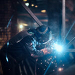 Welding work with metal construction at busy metal factory